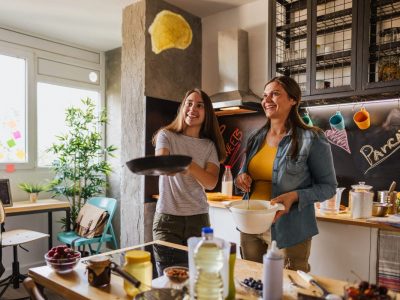 Photo of teenager girl with her mom makes pancakes